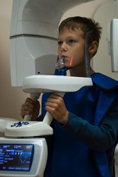 Jaw computed tomography, check up teeth in dental clinic. Little boy on x-ray diagnostics. Circular snapshot of jaw on modern medical equipment. CT scanning, stomatology and radiology.