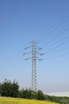 high voltage power pole and lines against the blue sky