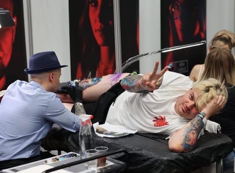 Krakow, Poland -  June 12, 2022: Unidentified  participant at 15th Tattoofest Convention in Cracow. One of the most prestigious tattoo festivals. Tattoo artist at work.
