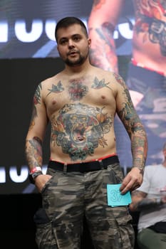 Krakow, Poland - June 11, 2022: Unidentified participant during the contest for the best tattoo at the 15th Tattoofest Convention in Cracow. One of the most prestigious tattoo festivals.