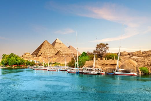 Ancient rocks and sailboats on the bank of the Nile, Aswan, Egypt.