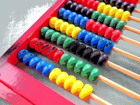 Education concept - abacus with many colorful beads. Red, blue, green, black, yellow details on the abacus. Mathematical exercises. School program.