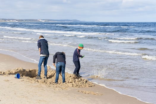 Children playing on the beach of the Polish Baltic Sea near Swinoujscie and want to build a sand castle
