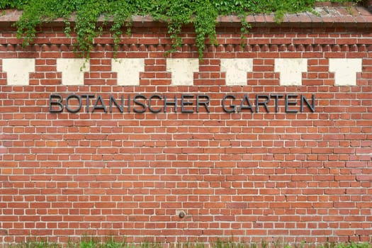 Wall with german lettering Botanischer Garten outside the garden at the entrance. Translation: Botanical Garden