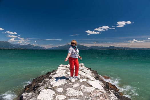 Lake Garda Italy. happy woman against the backdrop of emerald water