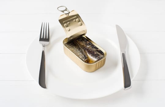 Canned sardines in olive oil on white plate conceptual shoot