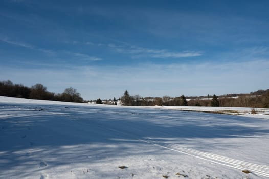 Lots of snow in nature, with trees and blue sky in the high Rhoen, Hesse, Germany