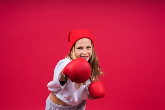 Little girl wearing red boxing gloves, studio shot, sport conception