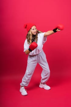 Little girl wearing red boxing gloves, studio shot, sport conception