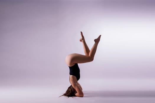 Image of a young plump female doing acrobatic stunt, studio shot