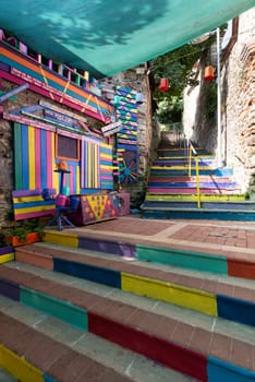 Exterior daytime shot of stone cafe decorated with multicolored panels colorful stairs, and canopy in Balat District, Istanbul, Turkey