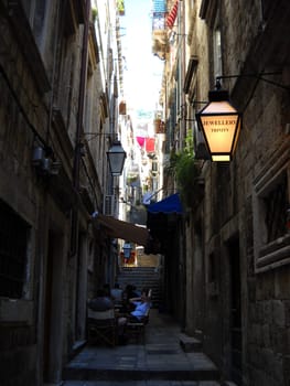 Dubrovnik, Dalmatia region, Croatia - August 5, 2010 Landmarks of Croatia. Cityscape of Dubrovnik. Old town of Dubrovnik. Narrow shadow streets. Walls, shutters, windows and a graceful street lamp