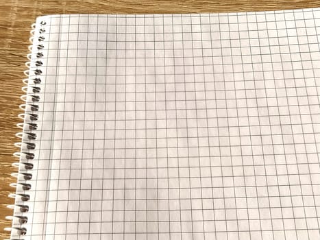 Checkered notebook with spiral. An open notepad for notes. Soft focus. Copy space. Blank blank page for your text.