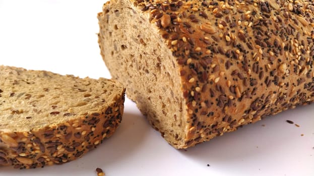 Fresh rye bread cut into pieces. White background. Bread with bran and seeds