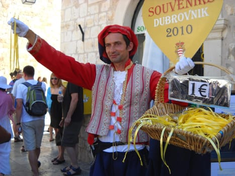 Dubrovnik, Dalmatia, Croatia, August 5, 2010. Dubrovnik Republic, Republic of Ragusa. A man in a national costume and a red beret sells souvenirs on the street. Traditional clothing of the Middle Ages
