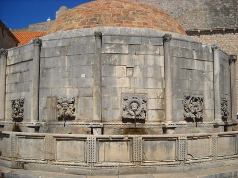 Dubrovnik, Dalmatia, Croatia, August 5 2010 The Great Onofrio Fountain on Stradun Street. The stone building is made in the form of a centric, faceted structure with decorations. Water supply network