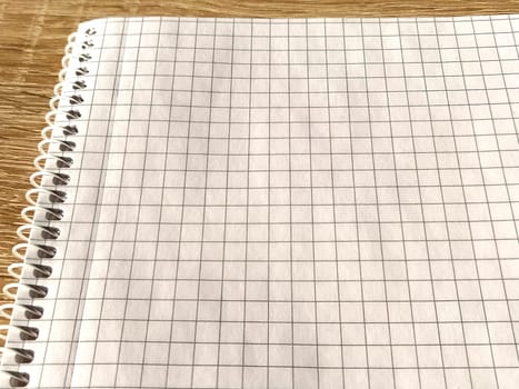 Checkered notebook with spiral. An open notepad for notes. Soft focus. Copy space. Blank blank page for your text.