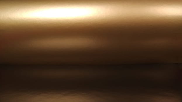 Gradient on a brown background. Horizontally folded shiny paper or foil with overflow and glare. Soft brown and beige color. Mysterious radiance. Northern Lights. Luxury fabric. Metallic gold glitter. Banner
