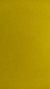 The paper or fabric is bright yellow. Close-up. Lightly folded sheet. Light gradient and accentuated rough surface texture. Background or product sample. Sunny cheerful yellow. Vertical