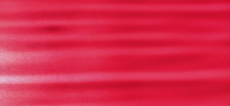 blurred striped sparkling pink background. Oblique horizontal beams of light on shiny fuchsia plastic surface.