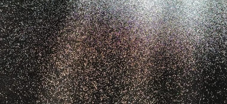 Light beam on black background with sparkles, radiance and sparkles. Festive background. Divine or moonlight effect. Rays falling from top to bottom. The spotlight is shining.
