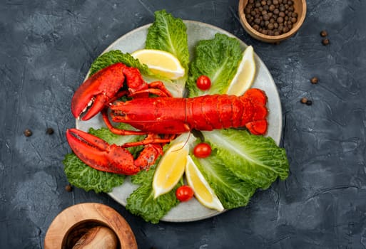 Boiled lobster with lettuce and lemon on a plate. Seafood, copy space