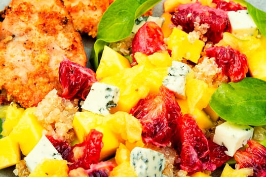 Salad with fruit, chicken breast and quinoa. Fruits salad with meat. Close up