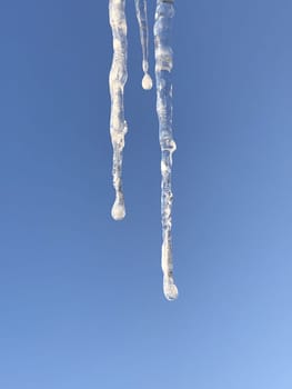 icicles on a blue background are a sign of the beginning of spring