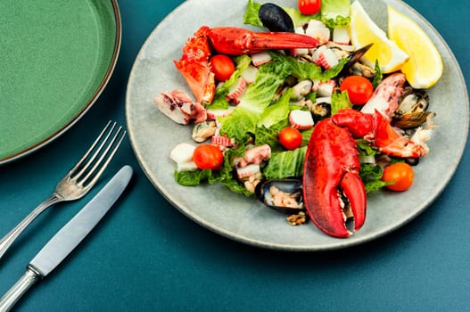 Tasty salad of oysters, mussels, lobster, lettuce and vegetables. Food background