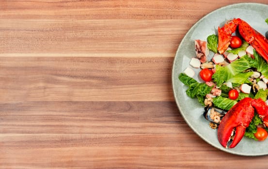 Tasty salad of oysters, mussels, lobster, lettuce and vegetables. Food background