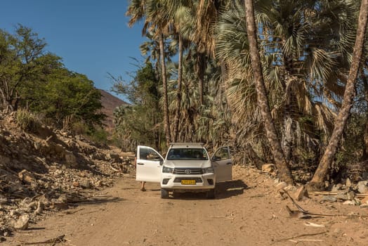 Car on a dusty gravel road along the Kunene River in northern Namibia