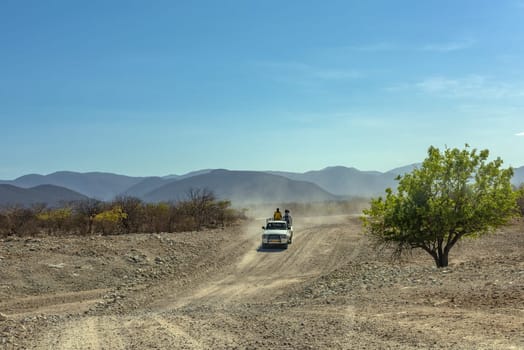 Car on a dusty gravel road along the Kunene River in northern Namibia