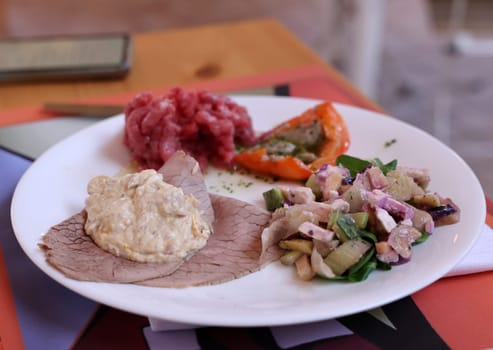 A delicious starter from Piedmont. Steak tartare, carpaccio, stuffed peppers, and salad