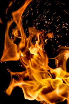 Background with fire and sparks in wind at night.