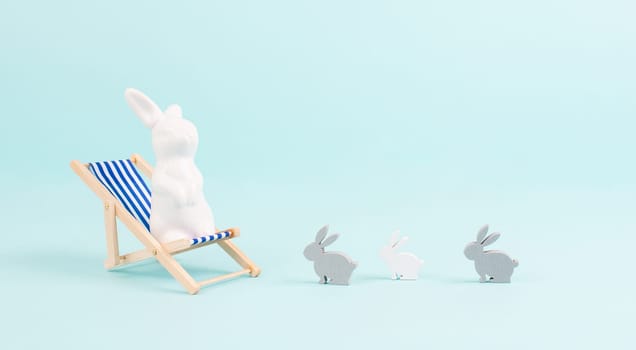 Bunny or rabbit sitting on lounge chair, kids next to mother, easter holiday, vacation by the sea