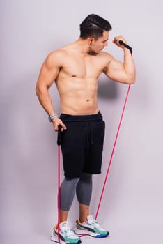 Athletic man skipping with jump rope on grey background. Best cardio workout