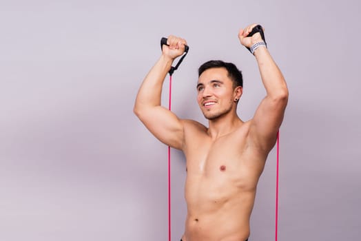 Athletic man skipping with jump rope on grey background. Best cardio workout