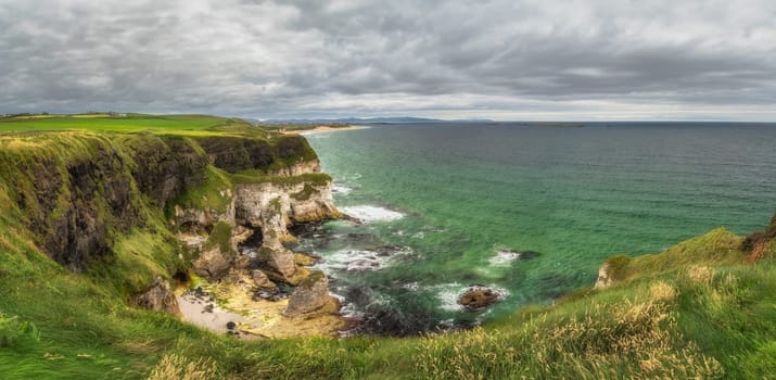 Panorama with white limestone rock formations and emerald water on beautiful Causeway Coast and Wild Atlantic Way, County Antrim, Northern Ireland