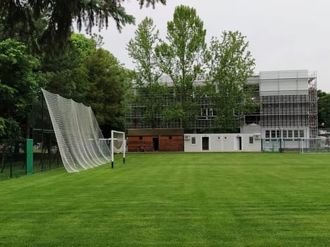 Sremska Mitrovica, Serbia. May 30, 2020. A football field on the school grounds and a football goal. The construction of a new school. School building in scaffolding. Facade work.