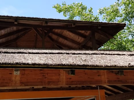 Reed roof on a modern wooden building. The roof is made from environmentally friendly natural materials, such as reeds or straw. Reed fire hazard coating.