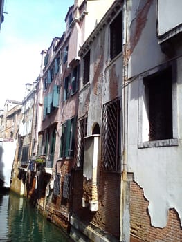 Venice, Italy, May 30, 2020. Narrow canal in Venice. Leaking plaster from the building due to high humidity. Architecture and landmark of Venice. Cozy cityscape of Venice