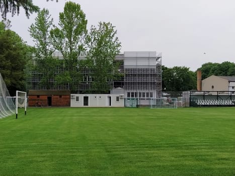 Sremska Mitrovica, Serbia. May 30, 2020. Construction of a new school. School building in scaffolding. Soccer field on the school grounds. Facade work at the final stage of construction.