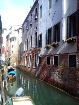 Narrow canal with gondola in Venice, Italy. Architecture and landmark of Venice. Cozy cityscape of Venice.