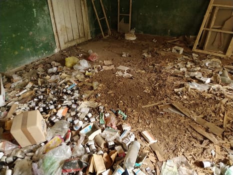 The interior of an old abandoned house. Lots of trash on the floor. Medical supplies, medicine bottles are not disposed of properly. The concept of the disposal of drugs. Obsessive-compulsive syndrome.