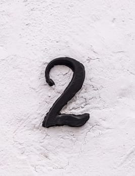 House number 2. Painted iron over whitewashed wall. Houses with personality concept