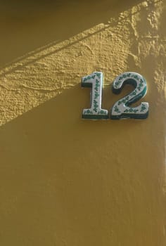 House number 12. Glazed decorated numbers. Houses with personality concept