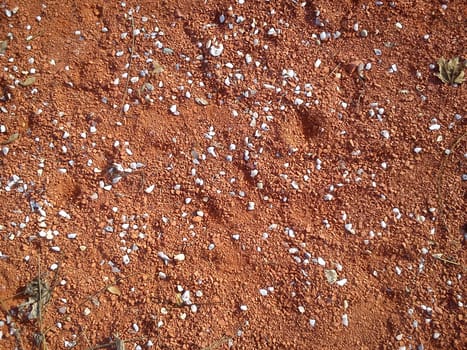 Fine decorative colored granite crushed stone. Red-brown colored stone chips used for landscape design. decoration and design. Crushed marble, granite, gravel or sand. Blotches of small white pebbles.