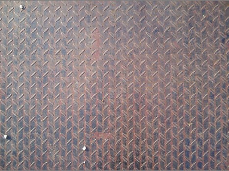 Fragment of a metal bridge with an uneven surface. Durable alloy with anti-slip relief. A few crayons of white pebbles