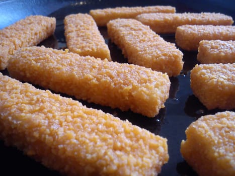 Fish or crab sticks fried in a cast iron skillet in vegetable oil. Fast food that has become carcinogenic after roasting. Diet Foods in Fish Menu.