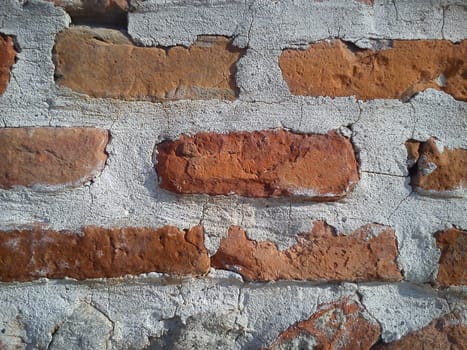 Old roman brick. The restored wall of the building of the Roman conquerors. Warm brown-red shades of uneven bricks. Archaeological site of Serbia.